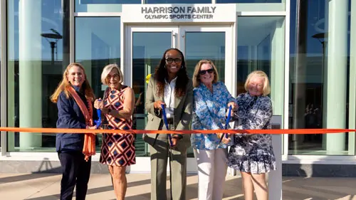 Women cutting the ribbon at the dedication of the Harrison Family Olympic Center