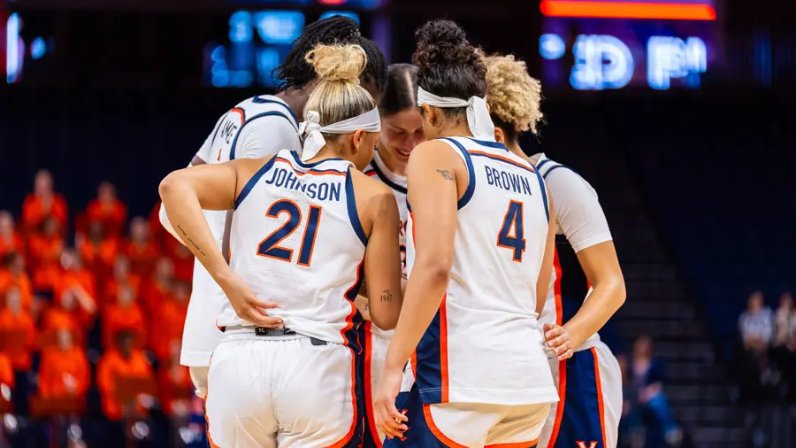 A mens basketball huddle on the court