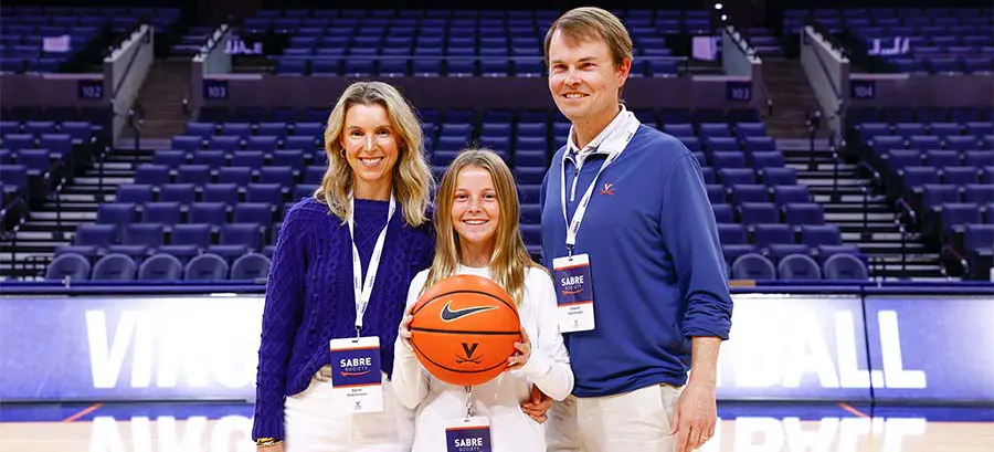 A man and woman posing holding up Virginia jerseys
